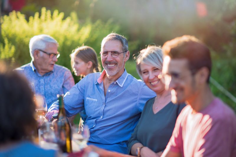 large family enjoying dinner outside