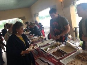 a group of people standing in a room with food