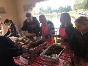 a group of people standing around a table with food