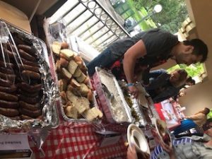 a group of people standing next to a table full of food