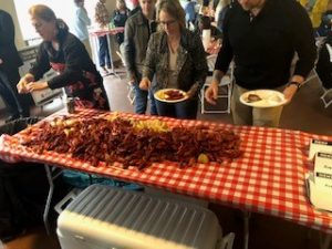 a group of people standing around a table full of food